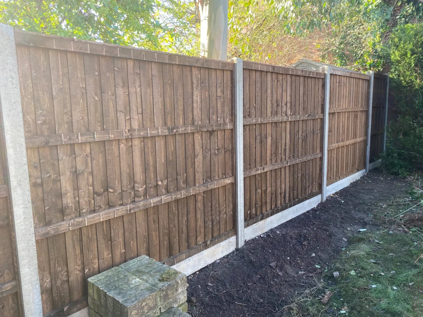 Brown closeboard fence panels fitted with concrete posts and gravel boards garden